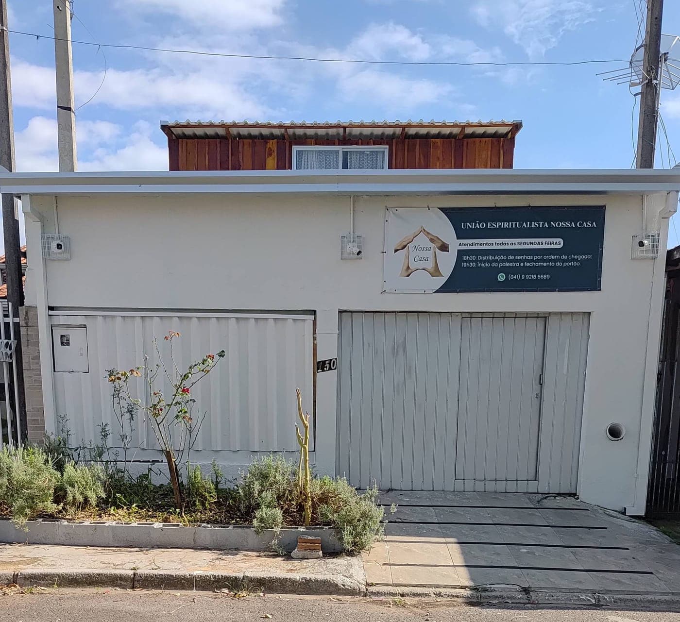 Fachada da Nossa Casa, com a placa de atendimento ao lado do portão