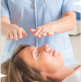 Uma pessoa com as mãos estendidas sobre uma mulher deitada, durante uma sessão de Reiki